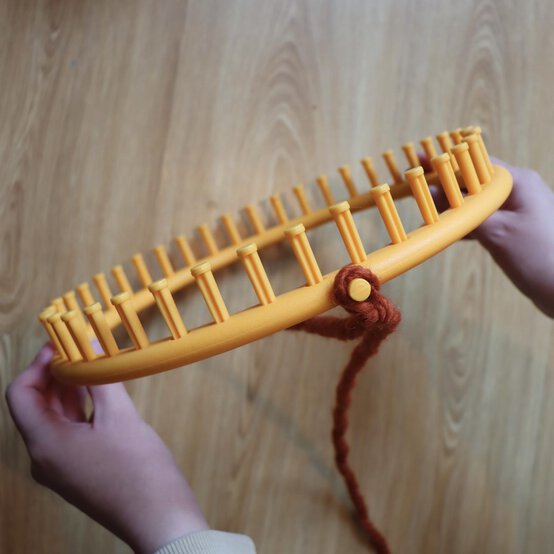 how_to_loom_knit_a_twisted_ear_warmer_step_1.jpg?sw=554&q=85