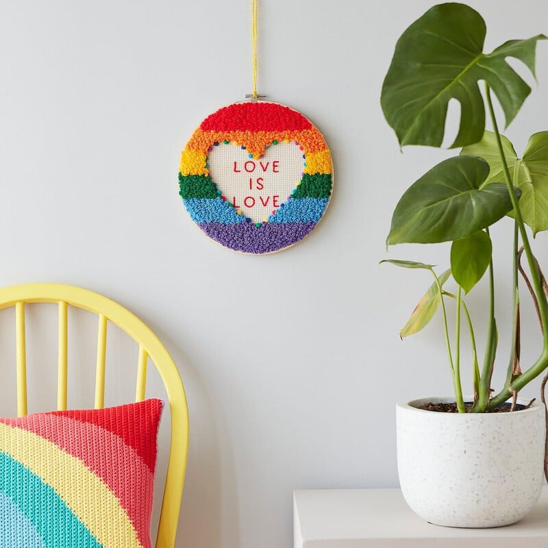 A Love is Love' Pride Punch Needle Hoop on a wall. Clicking leads to all ideas and projects