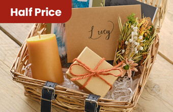 A wicker basket with shred and gifts in it. Half price badge. Clicking leads to hamper products.