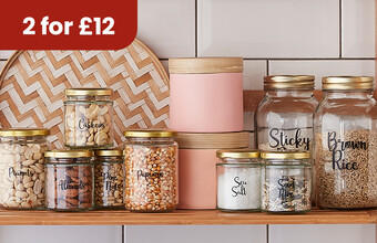 Glass jars on a shelf with food ingredients in them, all labelled with vinyl lettering. 2 for &pound;12 badge. Clicking leads to jar packs in the offer