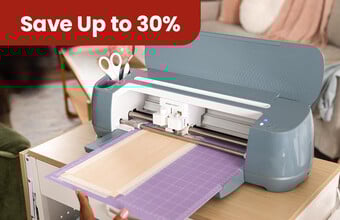 A cricut machine being set-up to cut some vinyl. A save up to 30%' badge. Clicking leads to cricut products on offer.