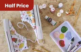 White trainers with hand painted fruit on them, wit open paint and brushes next to them. A red badge with half price. Clicking leads to fabric paint & pens.