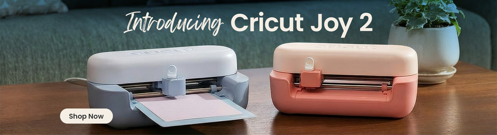A table with the new Cricut Joy in blue and coral on it. Header text says New Cricut, along with a Shop Now button and a price roundel that says Cricut Joy 2 &pound;129. Clicking leads to Cricut products
